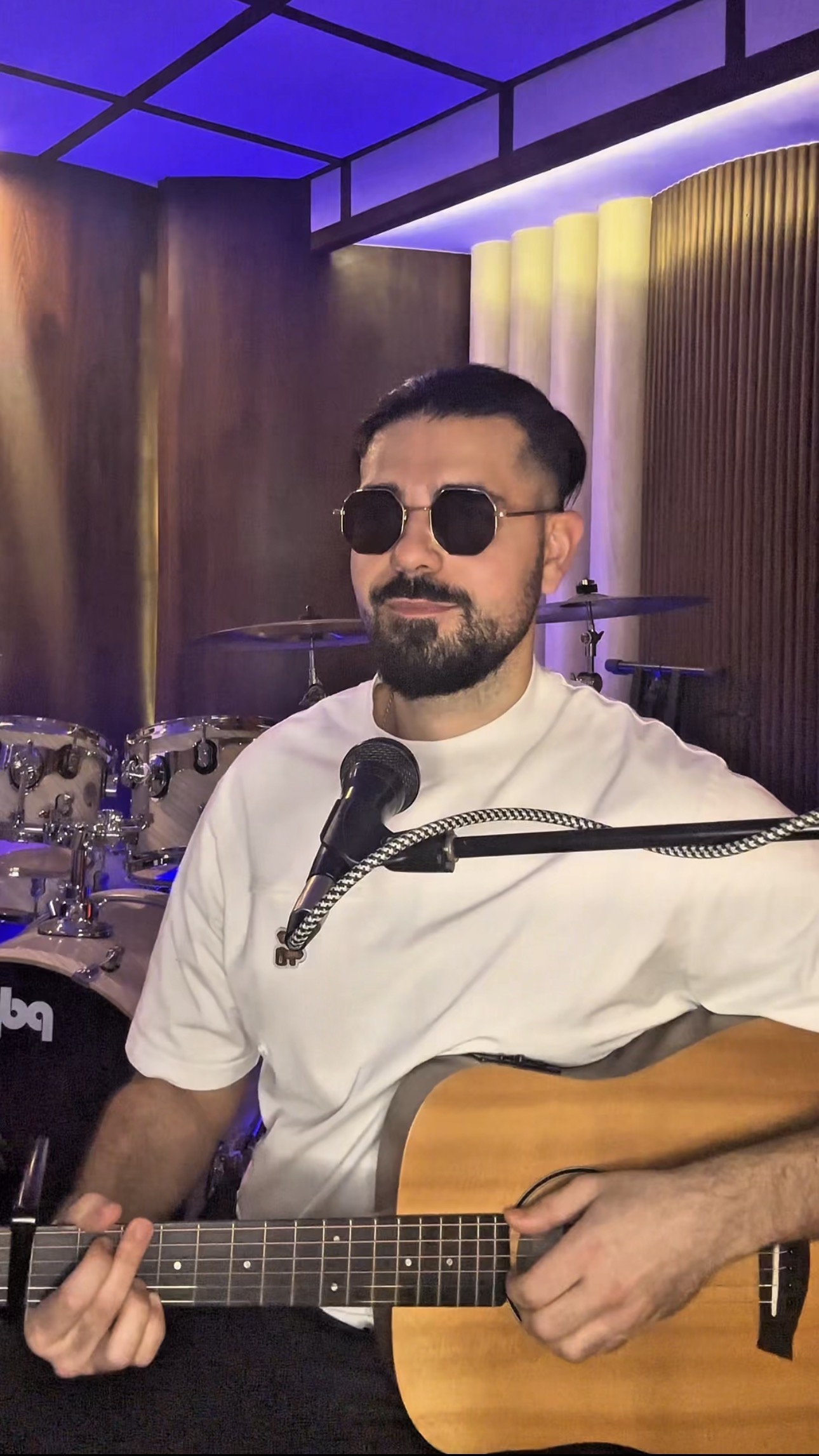 Yan London performing with guitar in the studio